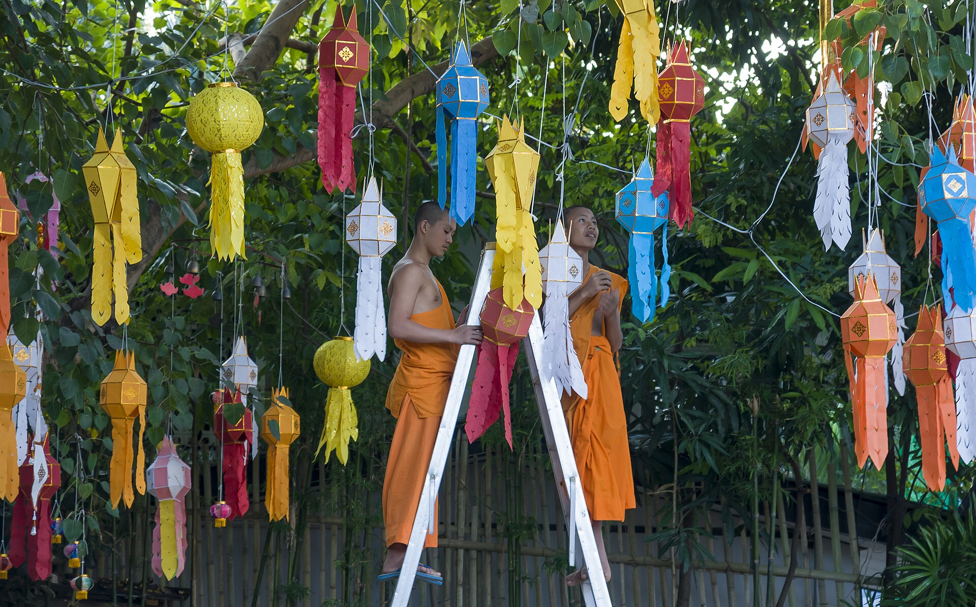 A saffron-robed Thai monk walking past a golden temple at dawn — the calm, spiritual side of life retirees enjoy in Thailand